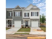 Charming two-story townhome featuring stone accents, a single-car garage, and a welcoming front entrance at 6005 Jasmine Branch Rd, Charlotte, NC 28216