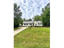 Charming one-story home with a well-manicured lawn and mature trees creating a serene setting at 730 Cove Rd, Gastonia, NC 28052