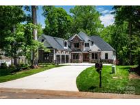 Beautiful two-story home featuring stone accents, modern garage doors, and a well-manicured lawn at 7703 Juniper Ln, Denver, NC 28037