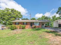 Charming single-story brick home with a well-maintained lawn and covered parking area at 876 Stowe Ln, Gastonia, NC 28056