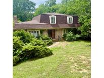 Charming brick home featuring a well-kept lawn, dormer windows, and mature landscaping at 9139 Robert Frost Ln, Charlotte, NC 28213