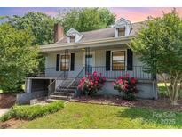 Charming home with landscaped front yard, featuring vibrant roses, inviting entrance, and classic architectural details at 952 8Th Ne St, Hickory, NC 28601