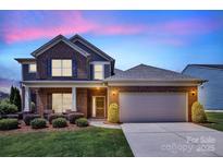Charming two-story brick home with well-manicured lawn and attached two-car garage at 1036 Squire Dr, Fort Mill, SC 29707