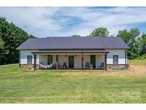Charming single-story home with a covered front porch featuring a hammock and rocking chairs, surrounded by a lush green lawn at 1138 Zeb Haynes Rd, Maiden, NC 28650