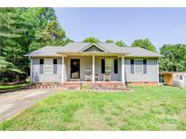 Charming single-story home with a welcoming front porch and well-maintained lawn and flowerbeds at 1170 Scenic Dr, Shelby, NC 28150
