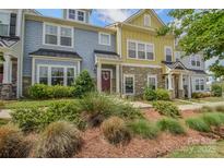 Charming townhome with stone accents, colorful siding, manicured lawn, and inviting front entrance at 12531 Bryton Ridge Pkwy, Huntersville, NC 28078