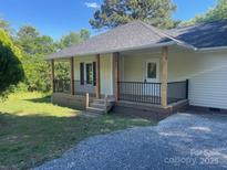 Inviting front porch with black railing, wooden posts, and a well-maintained yard at 1327 Wiscassett St, Albemarle, NC 28001