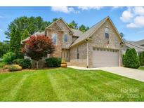 Charming brick and stone home featuring a manicured lawn and attached two-car garage at 1705 Townsend Ln, Rock Hill, SC 29730