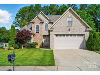 Charming brick home with lush green lawn, two-car garage, and mature trees offering curb appeal and Gathering comfort at 1705 Townsend Ln, Rock Hill, SC 29730