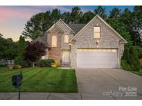 Charming two-story brick home with well-manicured lawn and attached two-car garage, perfect for Gathering living at 1705 Townsend Ln, Rock Hill, SC 29730