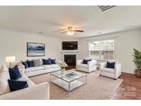 Bright living room with a cozy fireplace, plush seating, and a glass-top coffee table at 2515 Walnut Forest Dr, Charlotte, NC 28216