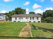 Charming single-story home featuring a well-manicured lawn, brick facade, and inviting walkway at 2633 N Sharon Amity Rd, Charlotte, NC 28205
