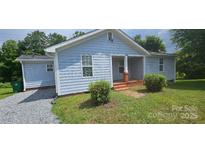 Charming single-story home with light blue siding, well-maintained landscaping, and a welcoming front porch at 2820 Bellhaven Cir, Charlotte, NC 28214