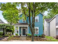 Charming two-story blue home with a welcoming front porch and beautifully landscaped front yard at 314 Center Dr, Davidson, NC 28036