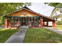 Charming home with a colorful exterior, inviting front porch, and convenient carport at 401 7Th St, Spencer, NC 28159