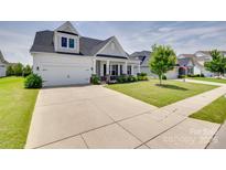 Charming two-story home with a two-car garage, well-manicured lawn, and inviting front porch at 4689 Kingswood Dr, Indian Land, SC 29707