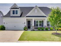 Charming home featuring a well-manicured lawn, white siding, stone accents, and a covered front porch at 4689 Kingswood Dr, Indian Land, SC 29707