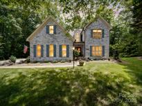 Charming white brick home with blue shutters, lush lawn, and manicured landscaping at 4715 Lenden Hall Ct, Gastonia, NC 28056