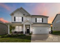 Charming two-story home with a well-manicured lawn, a covered porch, and a two-car garage at 5121 Ennisworth Ln, Charlotte, NC 28214