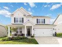 Charming two-story home featuring a well-manicured lawn, a covered porch, and a two car attached garage at 5121 Ennisworth Ln, Charlotte, NC 28214