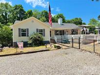 Charming home featuring an American flag, inviting front porch and lovely landscaping at 533 Tuckers Grove Rd, Statesville, NC 28625