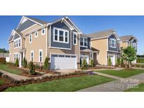 Charming townhome showcases manicured landscaping and a two-car garage on a sunny day at 7148 Hodges Meadow Ln, Charlotte, NC 28213