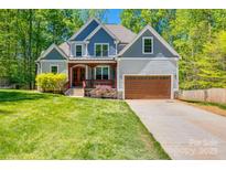 Charming two-story home featuring a manicured lawn, two-car garage, and inviting front porch at 7435 Hammond Dr, Charlotte, NC 28215