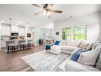 Bright living room boasts a large sectional sofa, neutral walls, and a modern ceiling fan at 7530 Porrera St, Charlotte, NC 28214