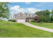 Charming home featuring a manicured front lawn, a long driveway, and a two-car garage at 8717 Swift Rd, Oakboro, NC 28129