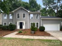 Charming two-story home with grey siding, black front door, and a well-manicured front yard at 10518 Fairway Ridge Rd, Charlotte, NC 28277