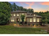 Stunning two-story home featuring stone accents, manicured landscaping, and a welcoming entrance at 11052 Preservation Park Dr, Charlotte, NC 28214
