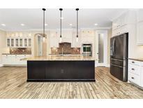 A spacious kitchen featuring a large island with granite countertops and stainless steel appliances at 11052 Preservation Park Dr, Charlotte, NC 28214