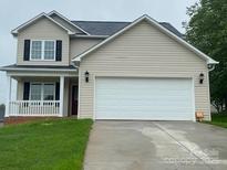 Two-story home features a two-car garage, covered porch, and neutral-colored siding at 1872 Terrain Nw Dr, Conover, NC 28613