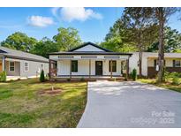 Charming renovated bungalow featuring a welcoming front porch and a well-manicured lawn at 253 Hall Nw Ave, Concord, NC 28027