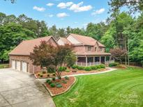 Stately brick home with a three-car garage, manicured lawn, and inviting wrap-around porch at 270 North St, Salisbury, NC 28147