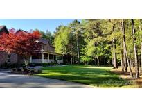Beautiful brick home featuring a lush lawn, well-manicured landscaping, and a charming front porch at 270 North St, Salisbury, NC 28147