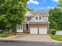 Beautiful two-story home featuring stone accents, a two-car garage, and mature trees providing shade at 3038 Sterling Ct, Fort Mill, SC 29707