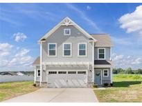 Charming two-story home with gray siding, a two car garage, and a well-manicured lawn at 32562-B Millingport Rd # 7155, New London, NC 28127