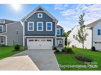 Charming two-story home with a blue exterior, manicured lawn, and an attached two-car garage at 32562-B Millingport Rd # 7155, New London, NC 28127