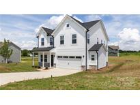 Two-story home featuring white siding, a front-facing two car garage, and a well-manicured lawn at 32616 Millingport Rd # 7144, New London, NC 28127