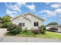 Charming single-story home with light siding, surrounded by beautiful landscaping and a clear blue sky at 380 Woodlawn Ave, Cramerton, NC 28032