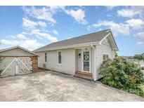View of house with painted siding, brick stairs, and a detached garage in the driveway at 380 Woodlawn Ave, Cramerton, NC 28032