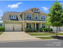 Charming two-story home features a well-manicured lawn, inviting porch, and a two car garage at 4013 Hamilton Mill Dr, Waxhaw, NC 28173