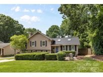 Charming two-story home featuring a well-maintained lawn, mature trees, and a cozy outdoor seating area at 4024 Tyndale Ave, Charlotte, NC 28210