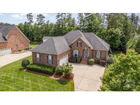 A brick home with dark shutters, a well-manicured lawn, and a curved driveway adds to the curb appeal at 4409 Winder Trl, Gastonia, NC 28056