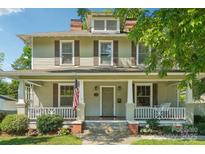 Charming two-story home featuring a welcoming front porch, classic shutters, and a well-maintained lawn at 448 Union S St, Concord, NC 28025