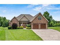 Beautiful brick home featuring a two-car garage, manicured lawn, and charming front yard landscaping at 5163 Meadow Park Ln, Hickory, NC 28602
