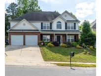 Charming two-story home featuring a well-manicured lawn, two-car garage, and brick and white siding at 5227 Eagle Creek Dv, Charlotte, NC 28269