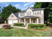 Charming two-story brick home featuring a well-manicured lawn, inviting front porch, and attached two-car garage at 5625 Linda Vista Ln, Charlotte, NC 28216