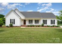 Charming single-story home featuring a covered front porch, manicured lawn, and classic architectural details at 6201 New Hope Church Rd, Marshville, NC 28103